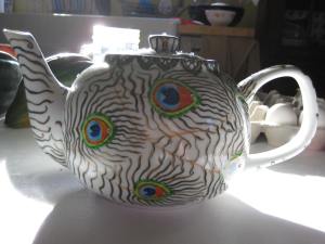 Started life as a plain Walmart Teapot; there are also rhinestones in the "eye" of the feather.